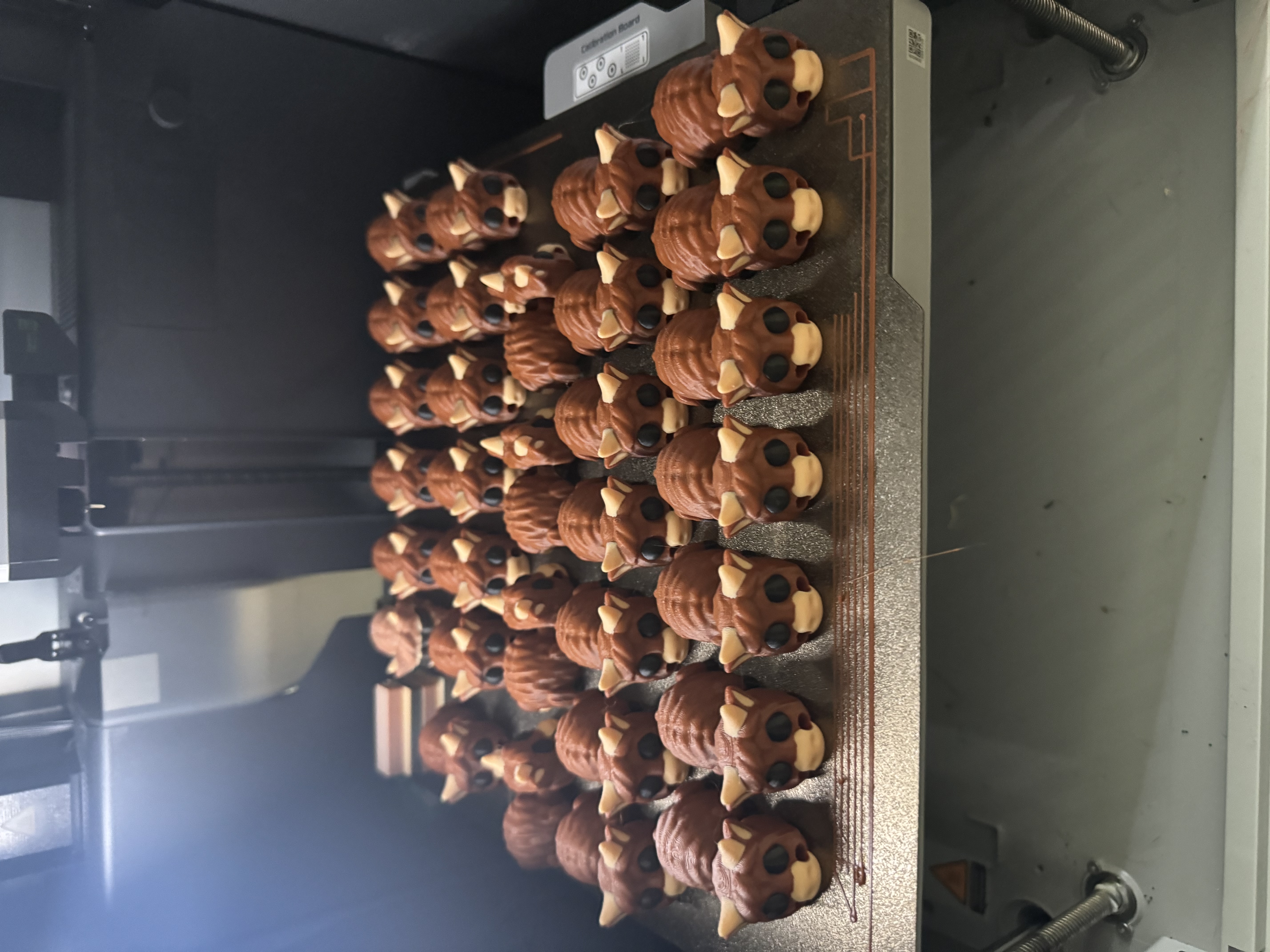 Full print bed of bear keychains — batch production